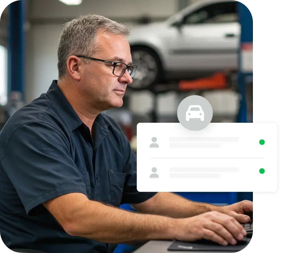 A close-up photo of a male mechanic wearing glasses, focused on his work in a professional workshop setting.